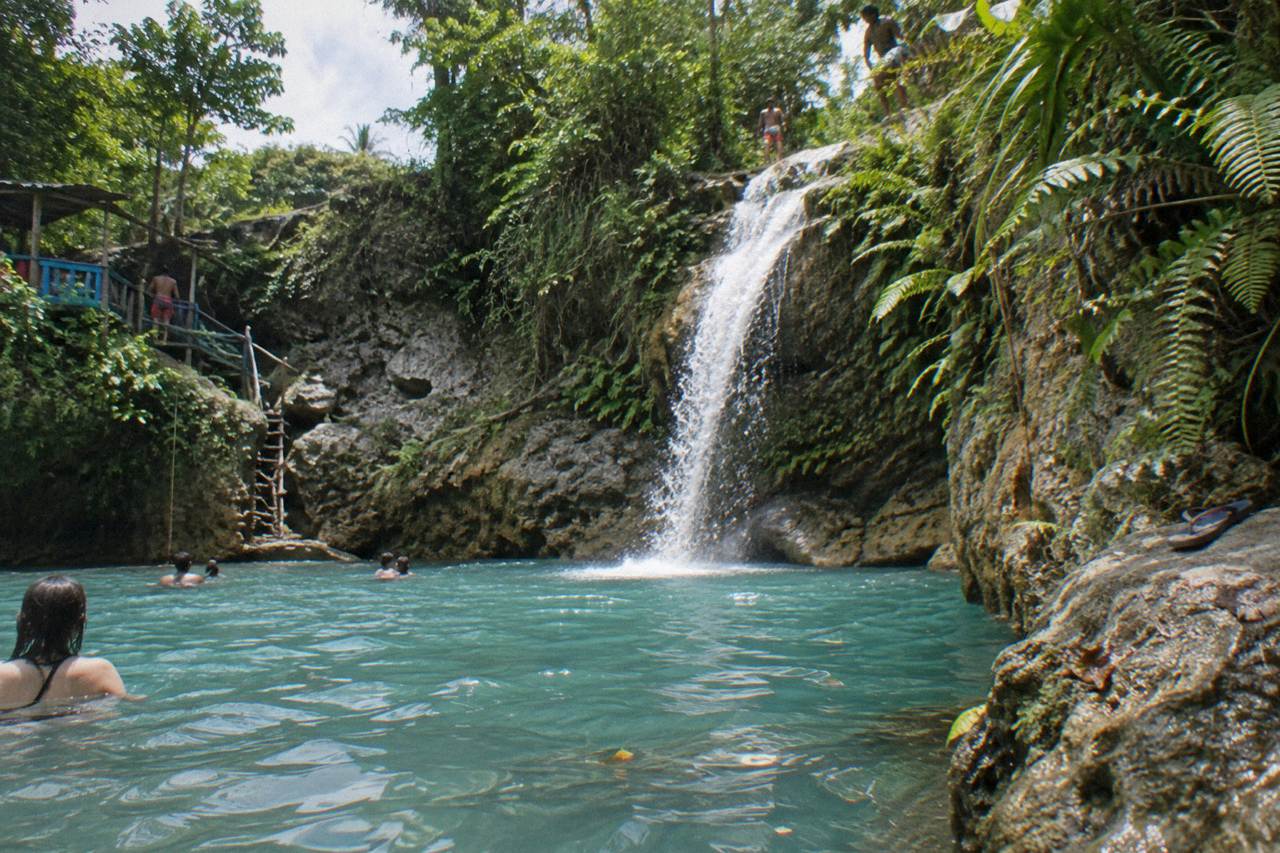 Turquoise waterfall pools surrounded by dense green forest in the hills above Ocho Rios.
