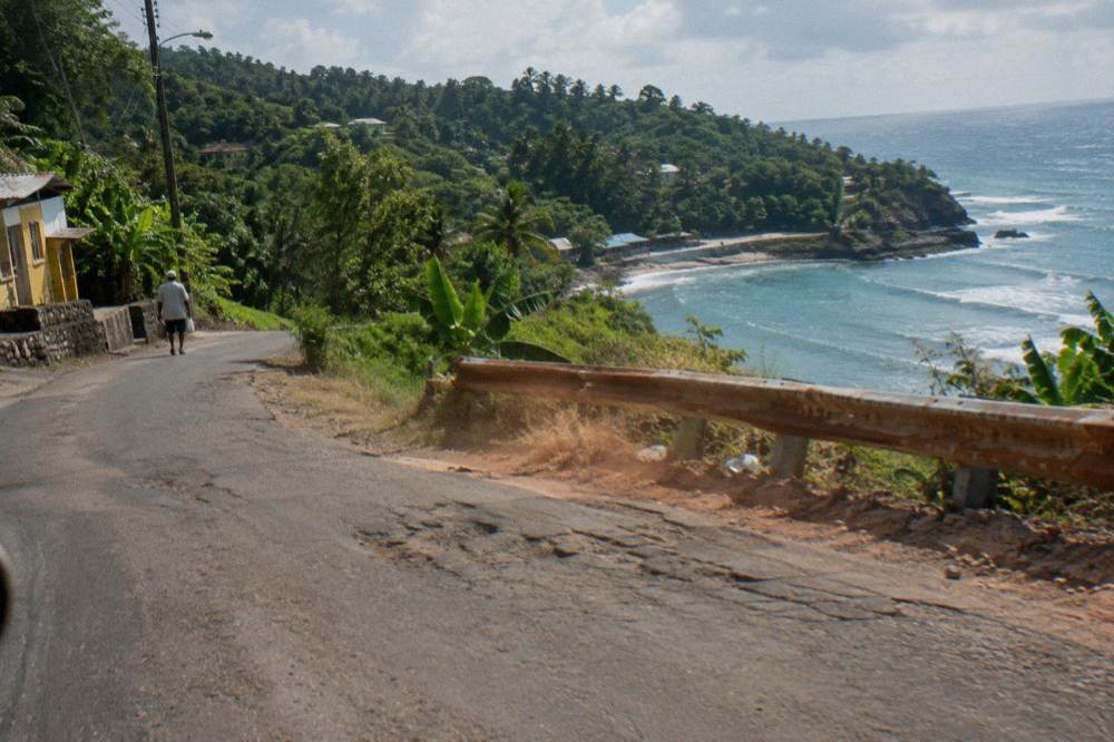 Winding country road through green hills on the drive to a Jamaica waterfall