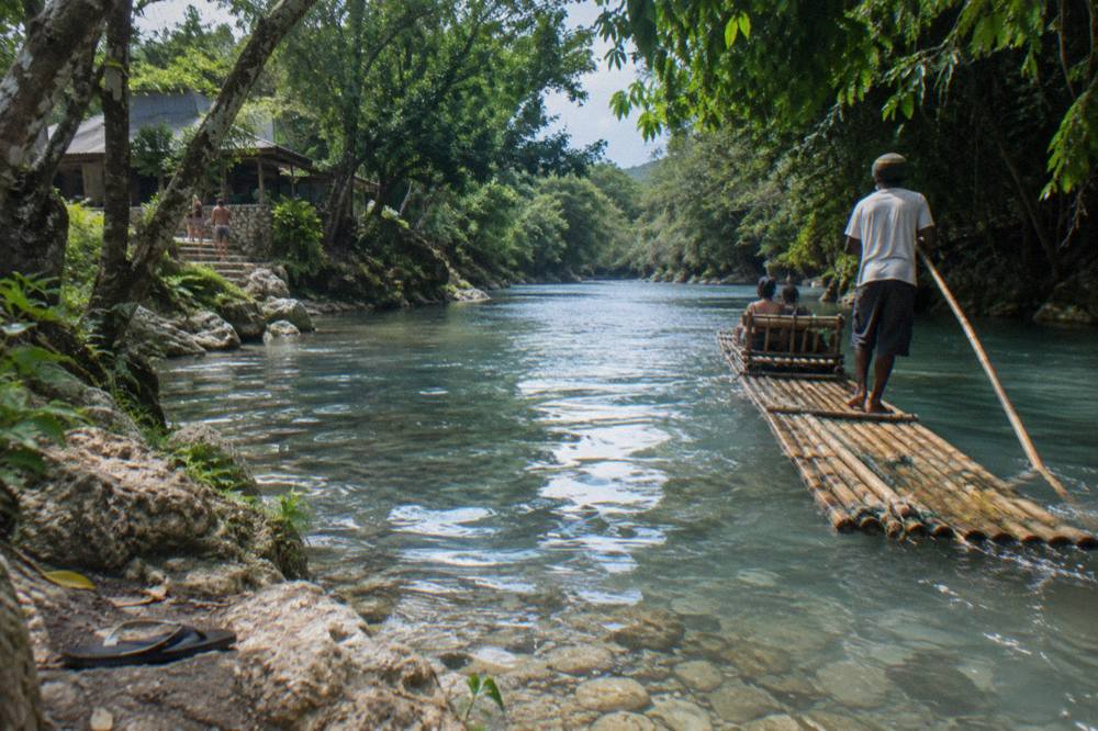 Bamboo raft drifting along a calm jungle river in Jamaica