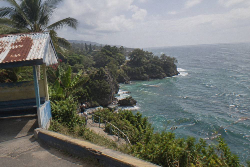 Coastal road curving along green hills above the Caribbean sea