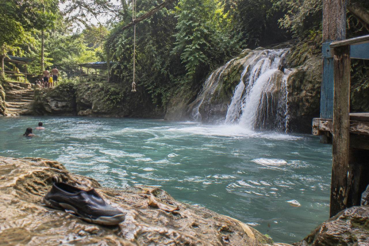 Turquoise waterfall pools surrounded by dense green forest near Ocho Rios