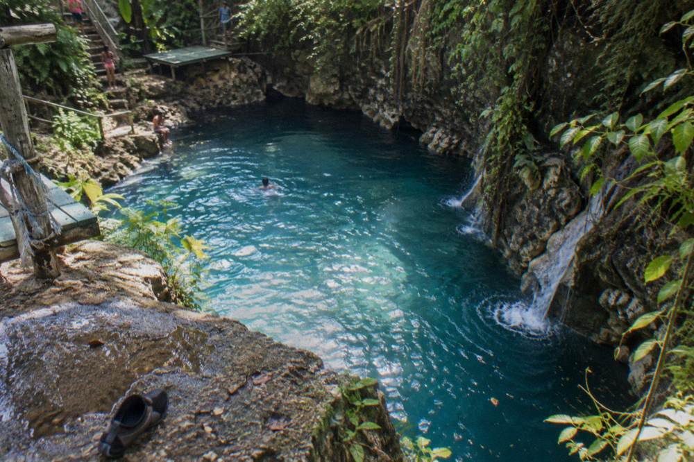 Sunlight on a calm blue pool between jungle cliffs in Jamaica
