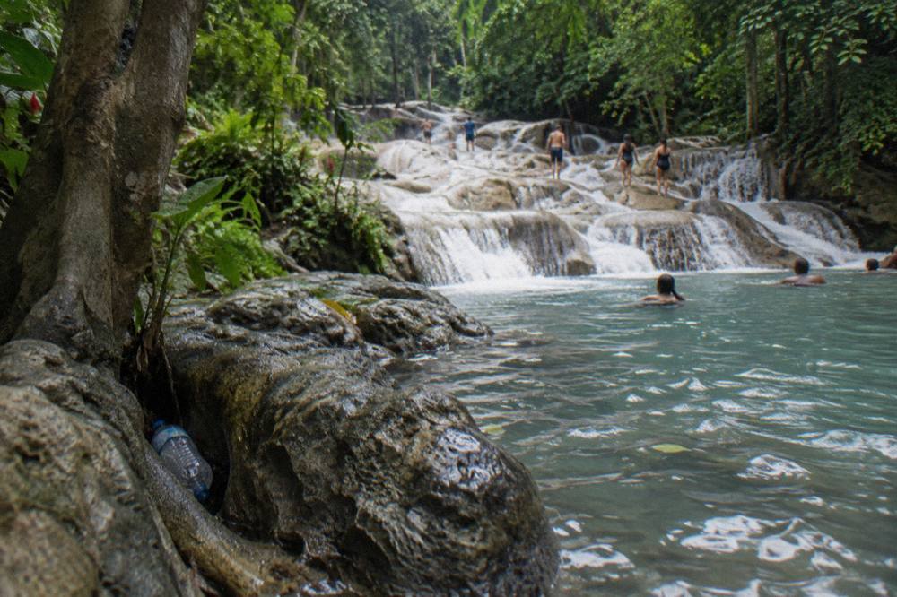 Cascading limestone waterfall steps with water pouring into a clear pool