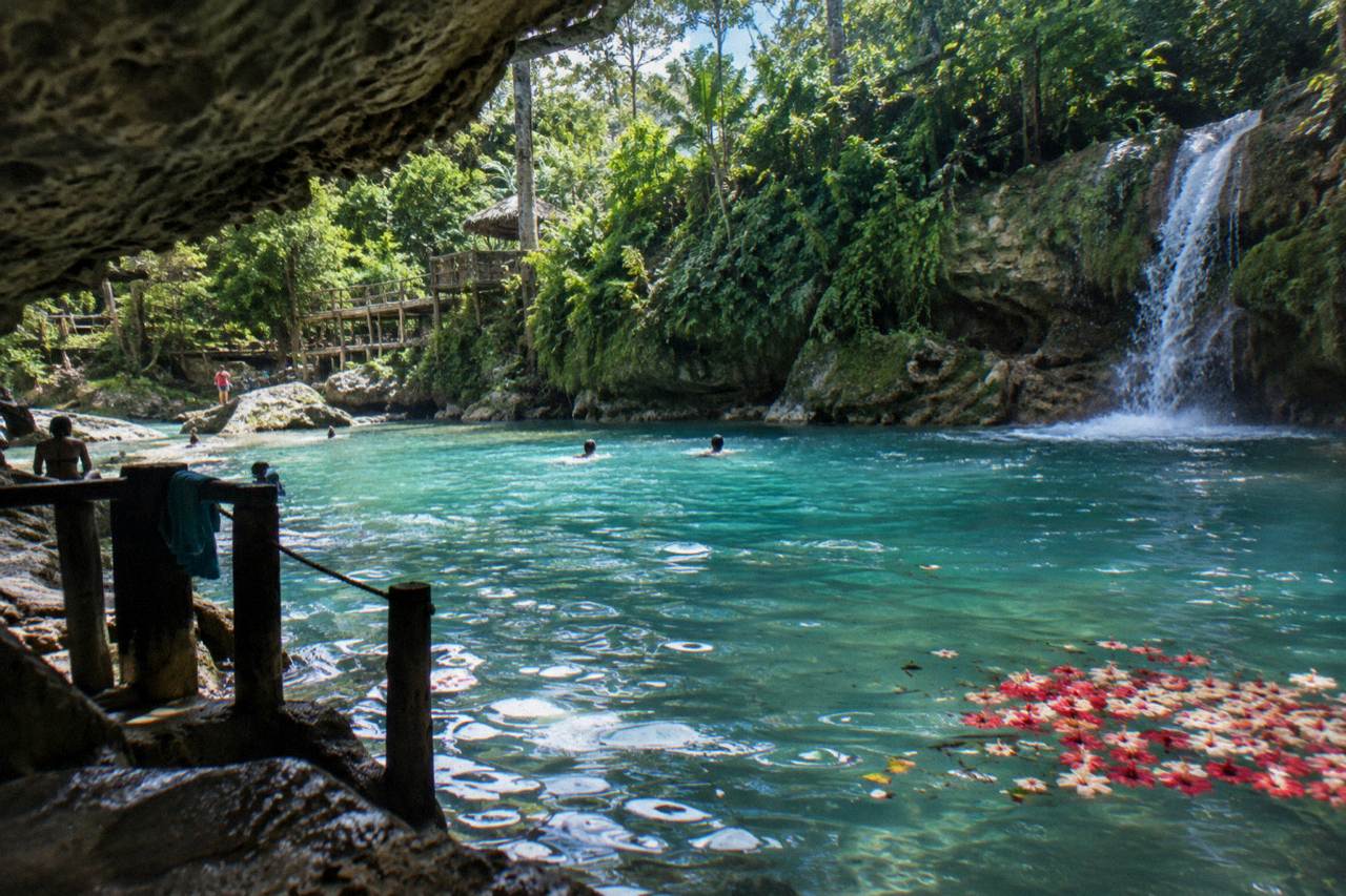 Turquoise waterfall pool surrounded by green forest at the Blue Hole near Ocho Rios
