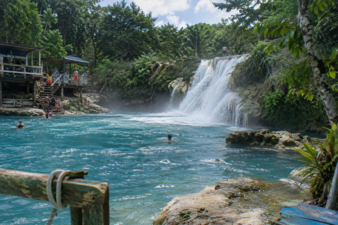 Turquoise waterfall pool surrounded by dense green forest at the Blue Hole near Ocho Rios