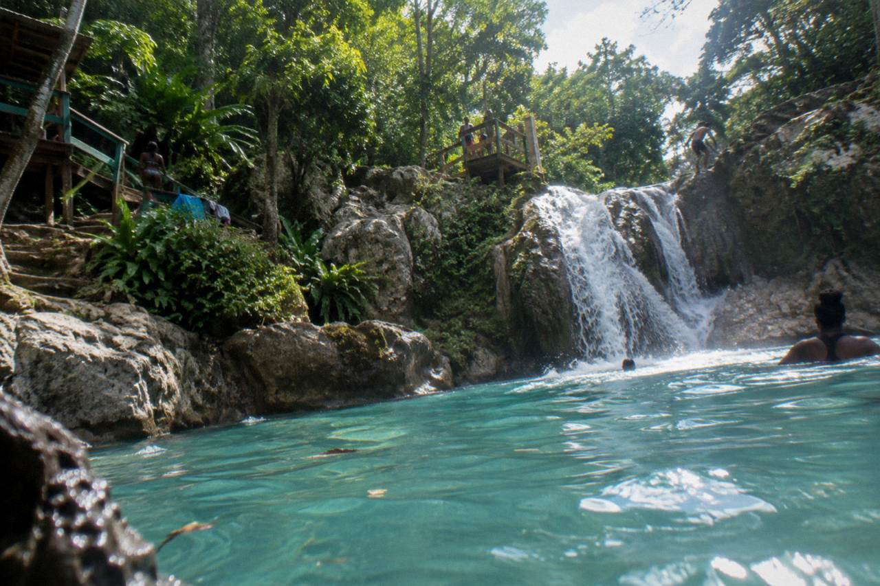Turquoise waterfall pool at the Blue Hole framed by green jungle and limestone rocks