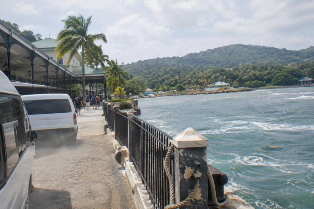 Cruise ship tender pier along a Jamaican coastline with tour vans waiting