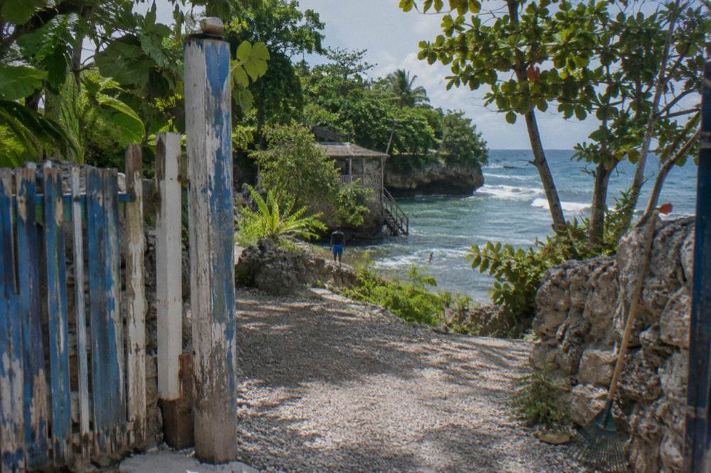 Wooden sign and entry gate at a Jamaican waterfall attraction