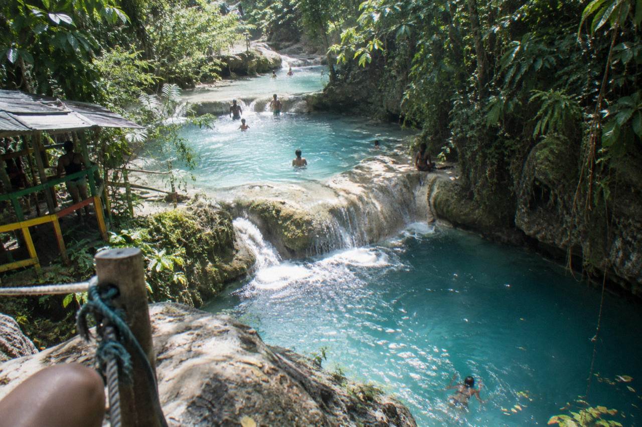Turquoise waterfall pool ringed by jungle foliage near Ocho Rios
