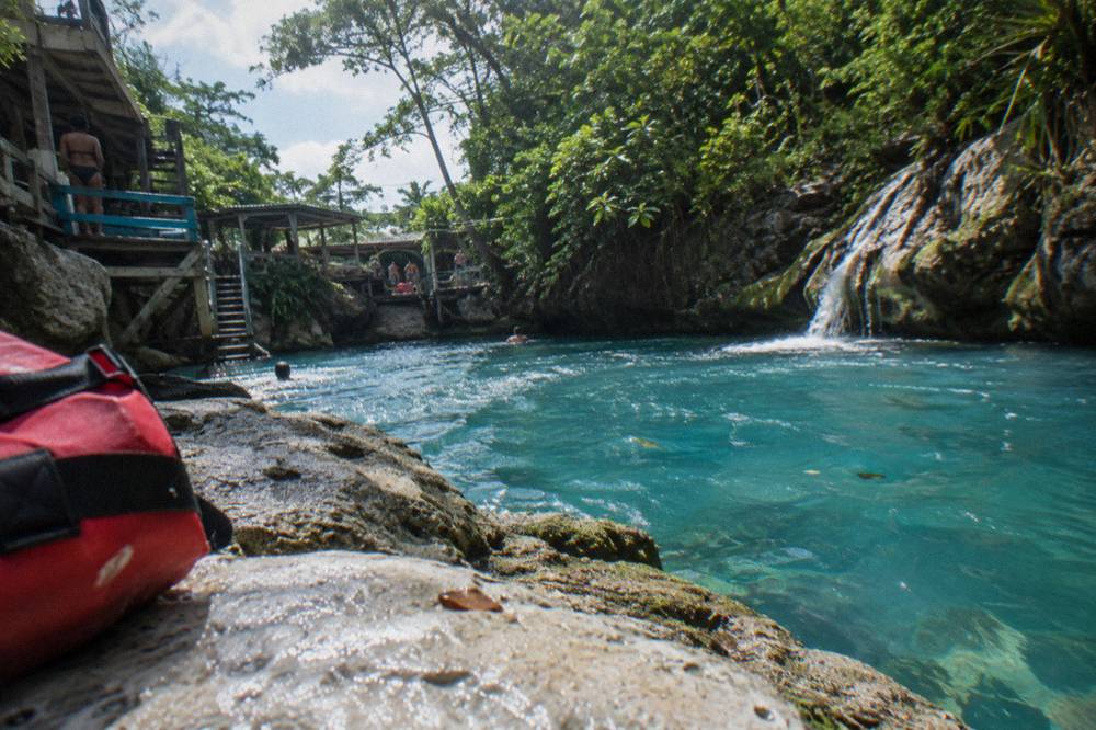 Water droplets and spray on limestone rock beside a bright turquoise pool