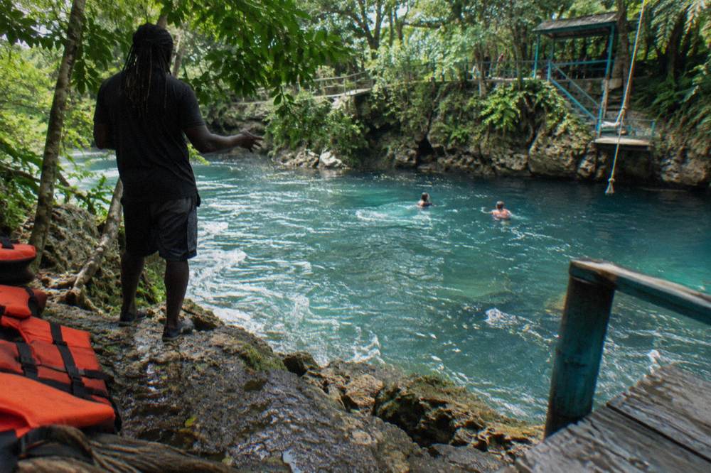 Tour guide speaking to a small group at the edge of a jungle pool
