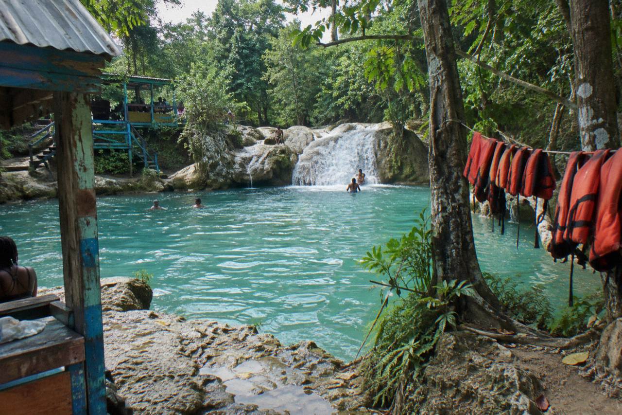 Turquoise pool at a jungle waterfall with limestone rocks and dense green forest