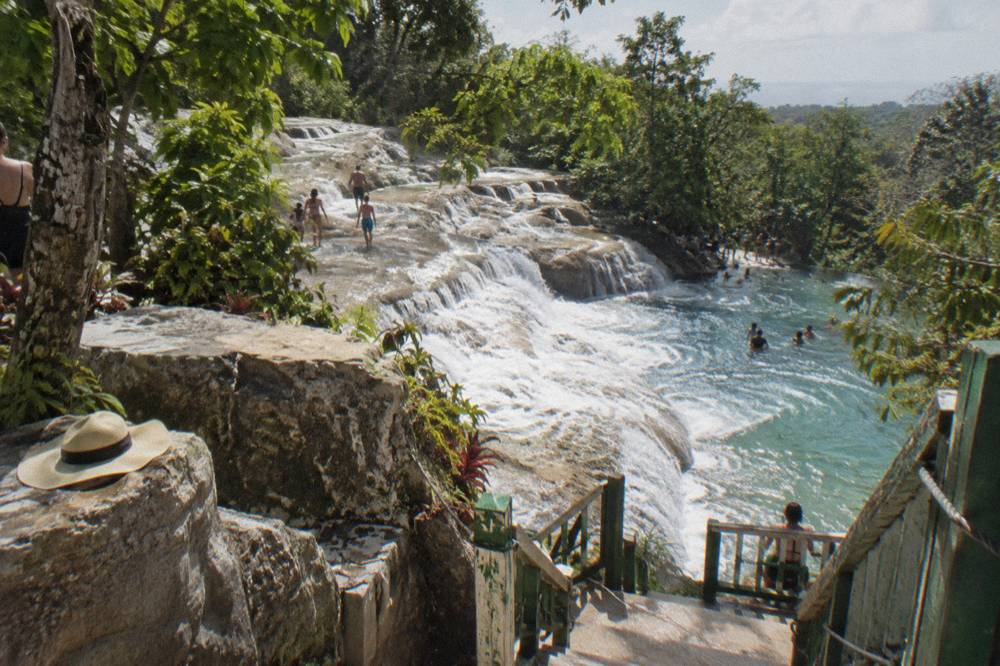 Terraced limestone waterfall with water pouring into a clear pool below