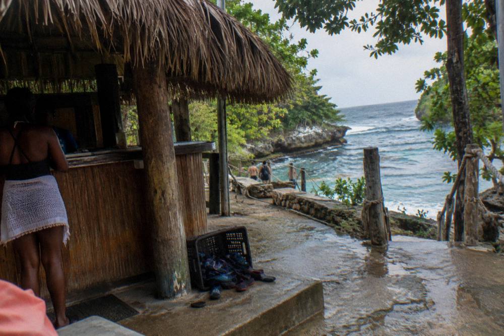 Ticket counter and thatched shade structure at a jungle waterfall attraction entrance