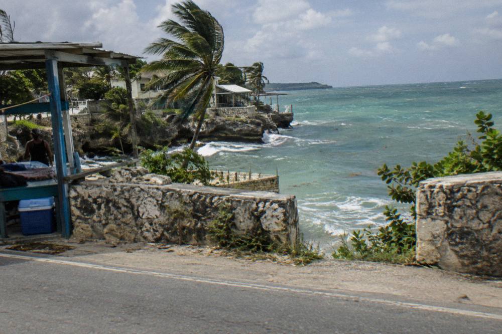 Coastal road curving along green hills above the Caribbean Sea in Jamaica