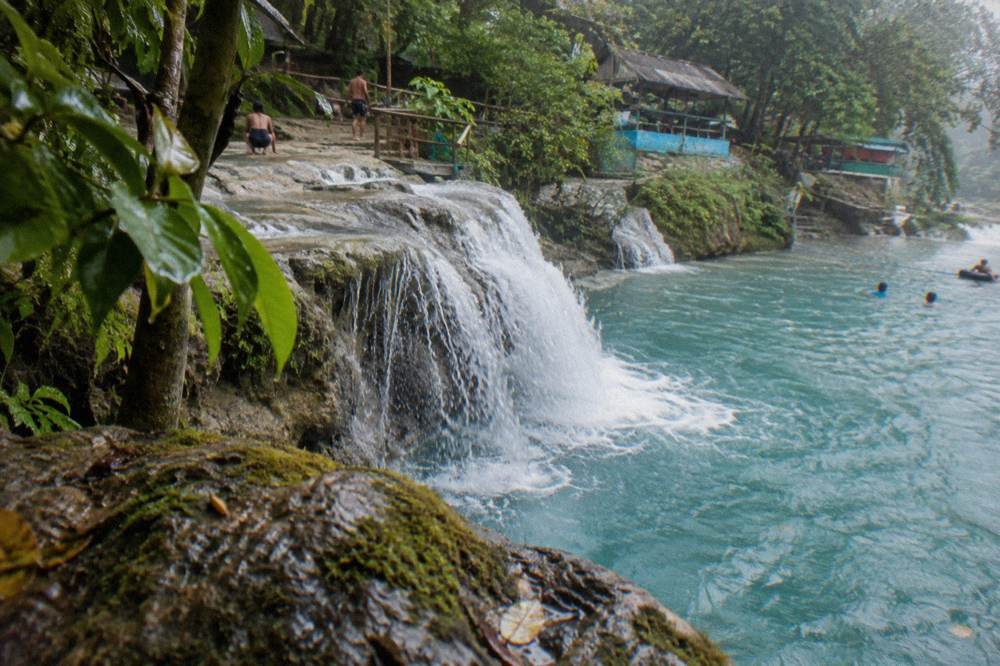 Terraced limestone waterfall cascading into a clear pool