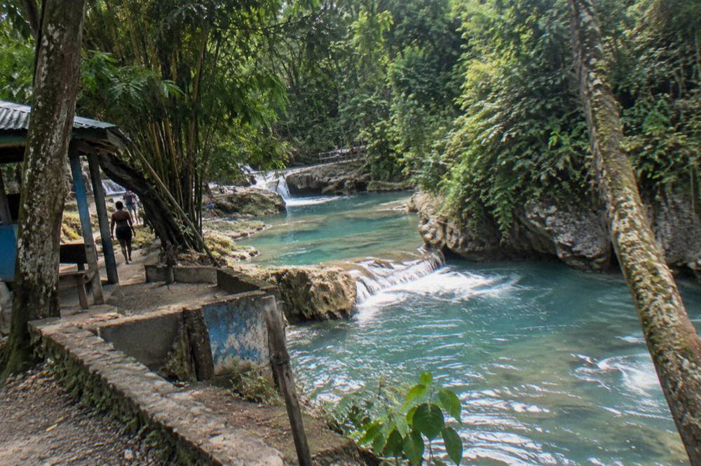 Turquoise jungle river pool between limestone rocks and rainforest
