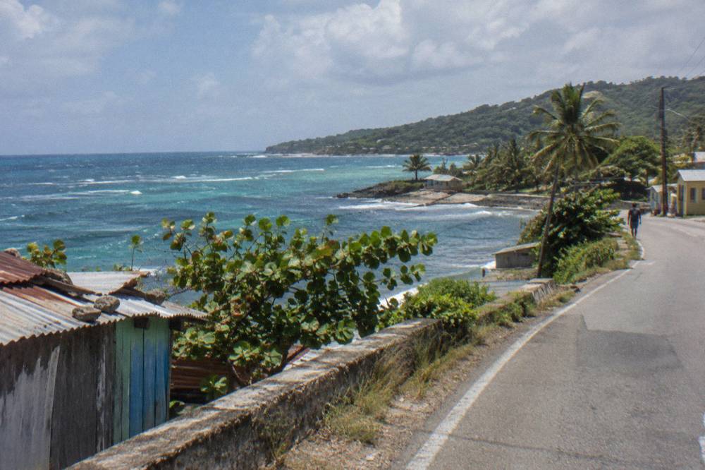 Coastal road curving along green hills above the Caribbean sea