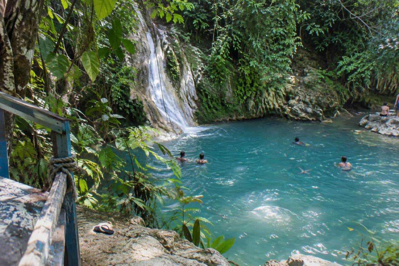 Turquoise waterfall pool ringed by jungle foliage at Island Gully Falls