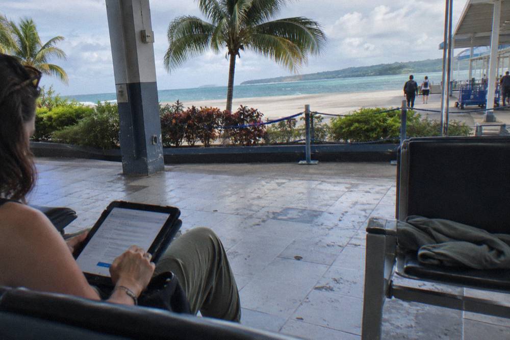A traveler filling in an online travel form on a tablet at an airport gate