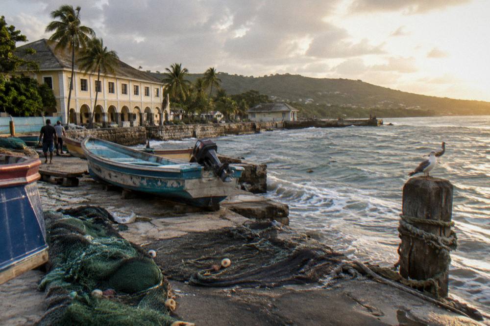 Small coastal town waterfront with fishing boats at golden hour