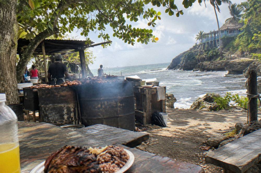 Plates of jerk chicken and pork served at an open-air roadside restaurant