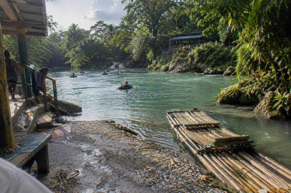Bamboo raft resting on a calm jungle river between green banks